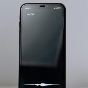 Smartphone exibindo assistente virtual de voz, representando buscas conversacionais e SEO para IA