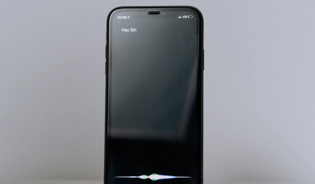 Smartphone exibindo assistente virtual de voz, representando buscas conversacionais e SEO para IA