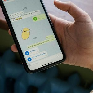 Mão segurando smartphone com aplicativo de mensagens aberto, representando Dark Social e tráfego invisível