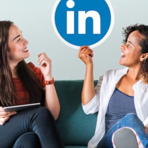 Profissionais de negocios segurando o logo do LinkedIn representando marketing B2B