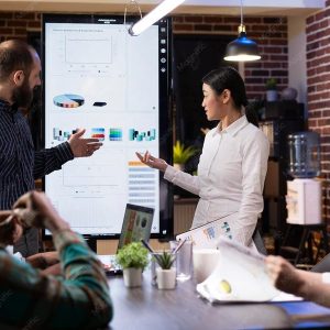 Equipe de marketing analisando estratégias em uma tela digital durante reunião de planejamento