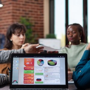 Equipe de marketing e vendas analisando gráficos de receita em um notebook