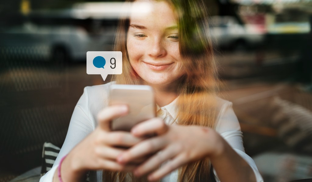 Jovem pesquisando em smartphone representando buscas em redes sociais